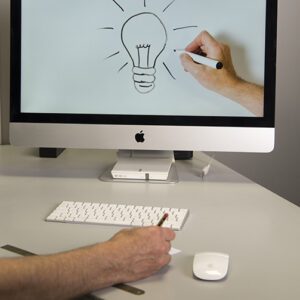 mano dibujando una bombilla a lapiz dentro de una pantalla de ordenador